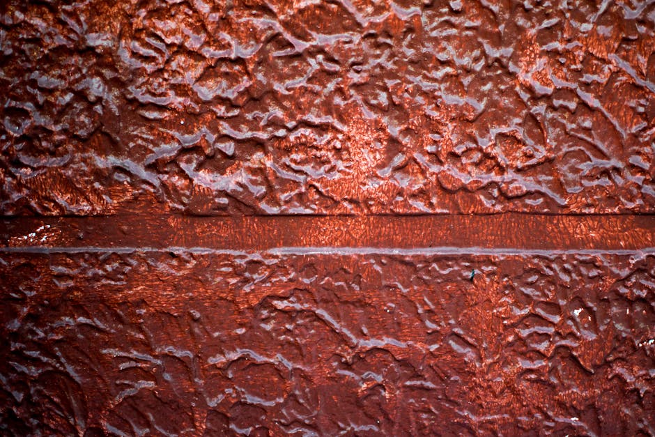 Detail of textured red brick wall surface showing rough patterns and texture.