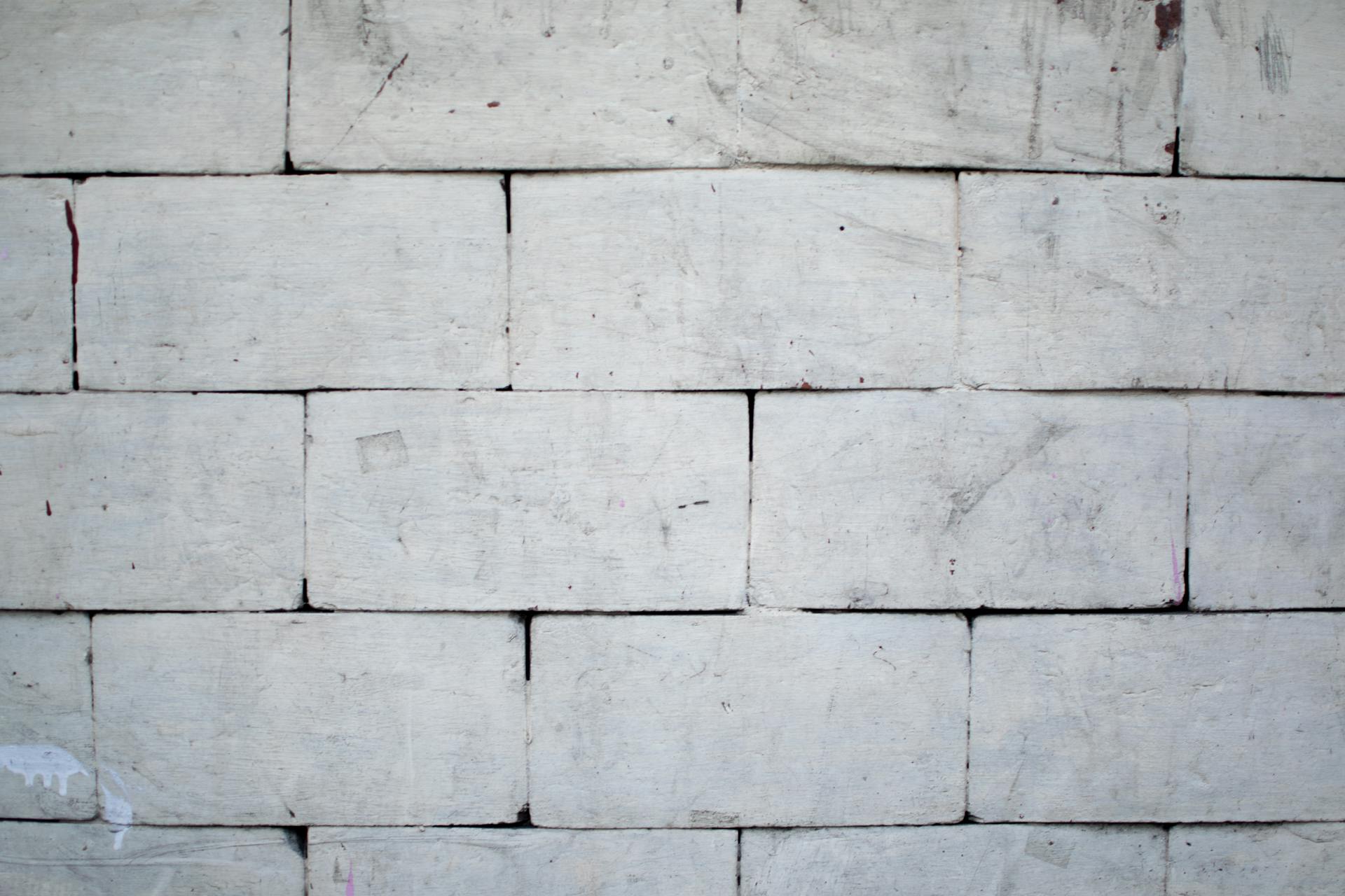 Close-up of a white brick wall with weathered texture and visible masonry details.