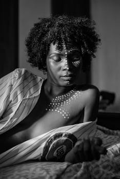 Black and white portrait of a woman with artistic body paint, expressing elegance.