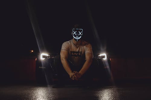 Photo of Man Wearing Mask in Front of Car