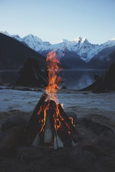 以雪山为背景的湖畔营火十分宁静，非常适合户外和旅行主题