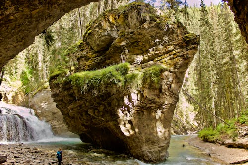 Frau, Die Nahe Wasserfälle Und Riesige Felsformation Steht