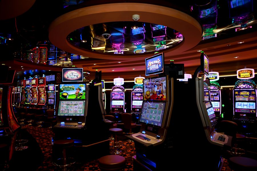 Interior kasino dengan deretan mesin slot menyala