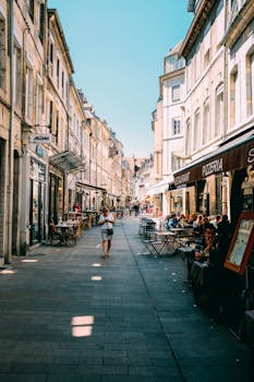 古色古香的欧洲街景中，咖啡馆与行人共同捕捉了城市的夏日氛围