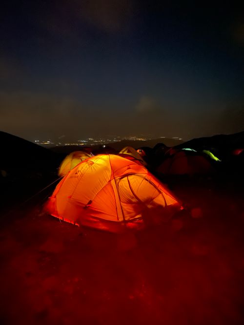 Free Glowing tent under night sky in outdoor camping setting, serene and adventurous. Stock Photo