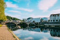 这座风景优美的河畔小镇，拥有现代建筑和一座桥梁，倒映在平静的蓝天碧水之中