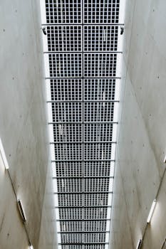 现代天花板设计采用了网格状面板和混凝土墙作为特色