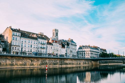 Free Picturesque canal with historic buildings reflecting in calm water under a vibrant sky. Stock Photo