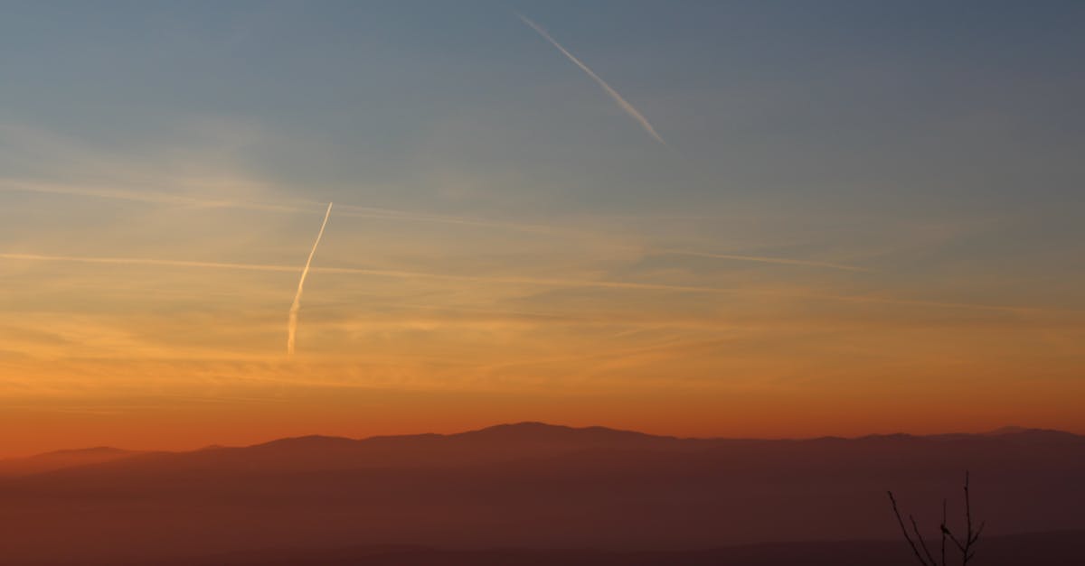 Silhouette Landscape Against Vapor Trails in Sky