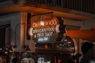 霓虹灯标志点亮了！墨西哥美食和塔可店在城市的夜色中
