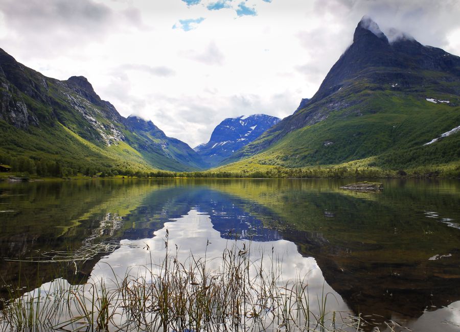 Stunning view of Norwegian mountains reflected in a tranquil lake, capturing serene nature.