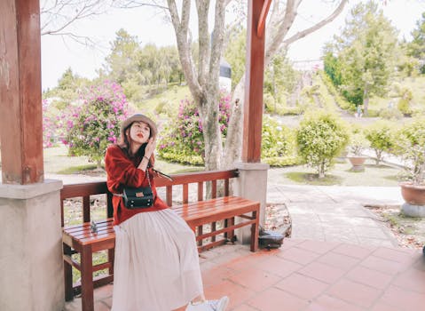 一名年轻女子坐在公园的木凳上，在充满活力的氛围中享受宁静时刻