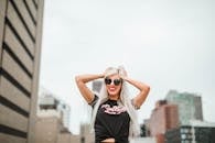 一位时尚女士戴着太阳镜，自信地站在城市屋顶上，拥抱着辛辛那提充满活力的天际线