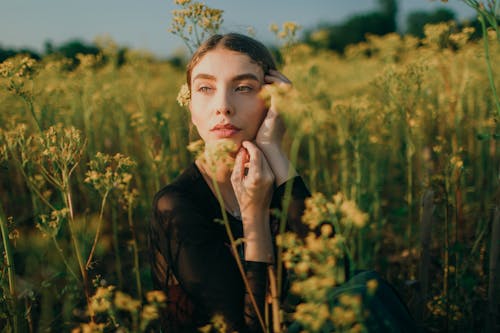 Close-Up Photo of Woman Sitting on Flower Field