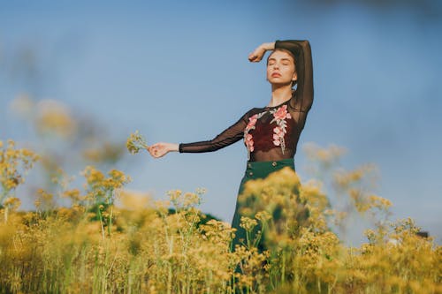 Woman Standing on Yellow Flowers