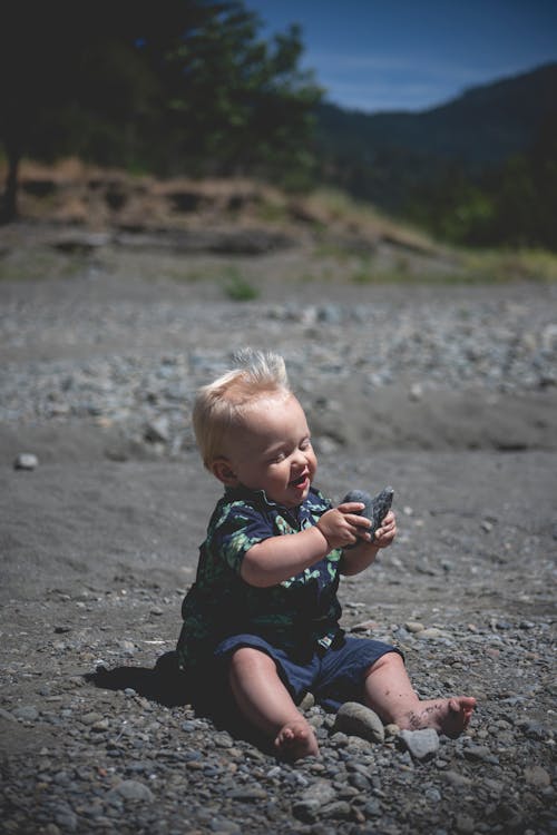 Free Toddler Sitting on Gray Sand Stock Photo