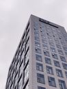 法兰克福一座现代摩天大楼的低角度视图，展示了其窗户与城市建筑