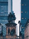 法兰克福市中心的雕像被现代摩天大楼包围，这非常适合描绘城市对比