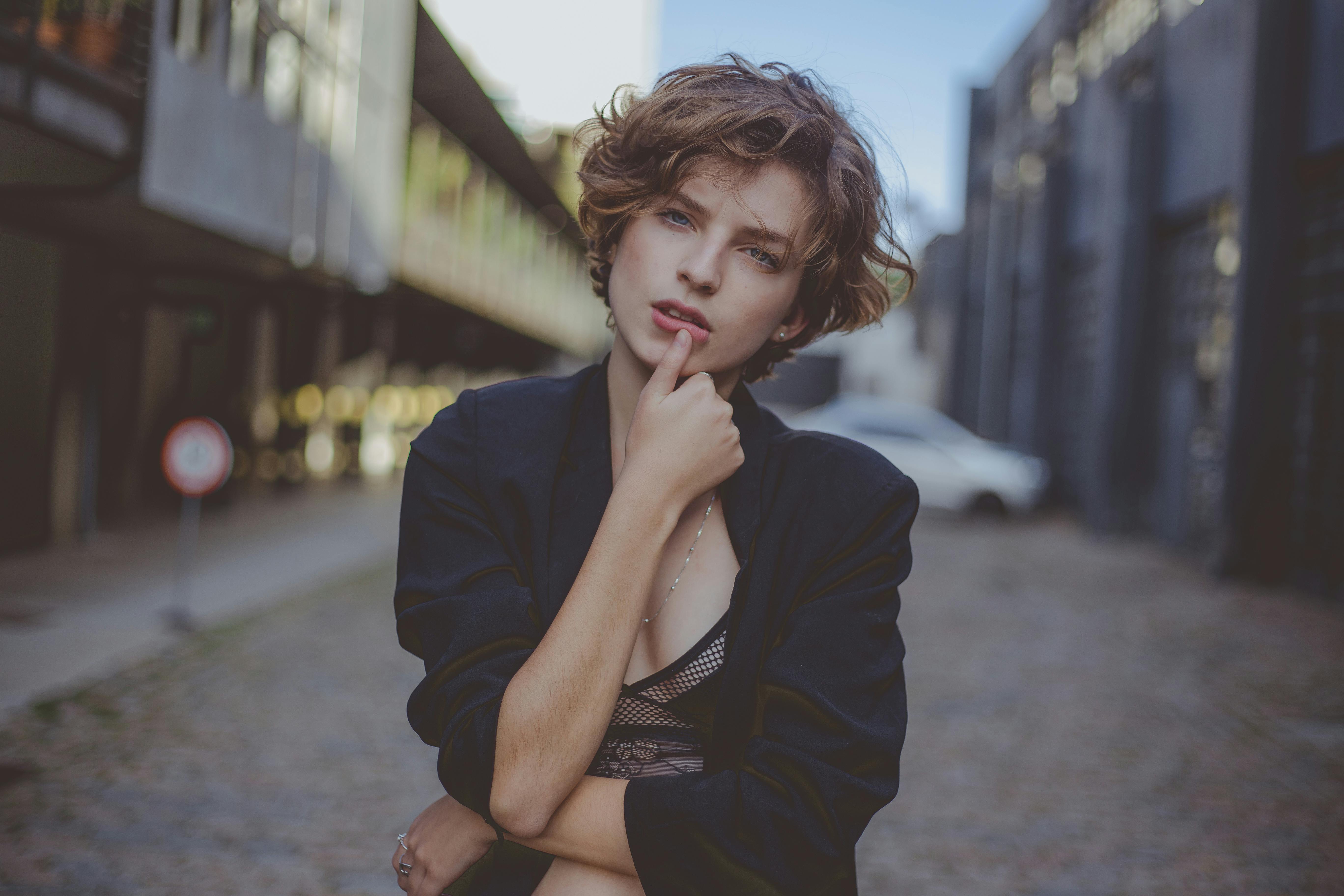 城市环境中，一位时尚的年轻女性姿态从容，散发着现代时尚风格