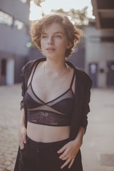 Young woman poses confidently outdoors in fashionable attire.