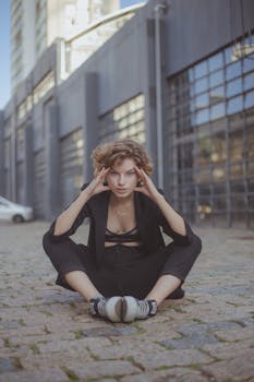 城市环境中，一位女人坐在石头人行道上的现代肖像