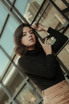 一位时尚的年轻女子在城市屋顶的梯子上，散发着沉思的气息