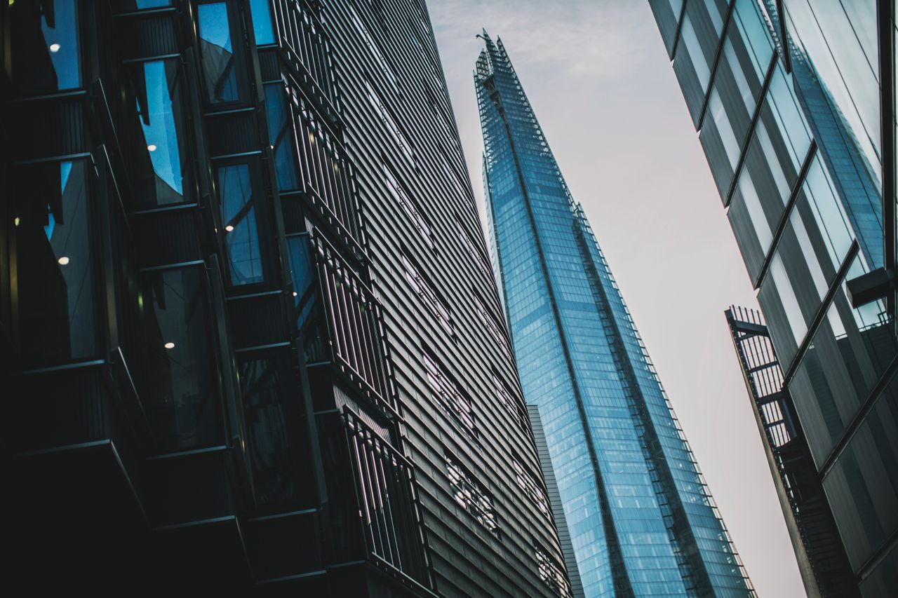 a dramatic low angle shot of modern skyscrapers including the shard in