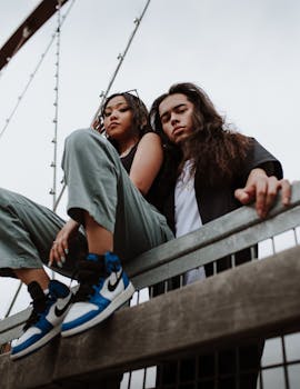 一对时尚的年轻夫妇在芝加哥的一座城市桥上摆姿势，凸显了现代时尚与城市生活