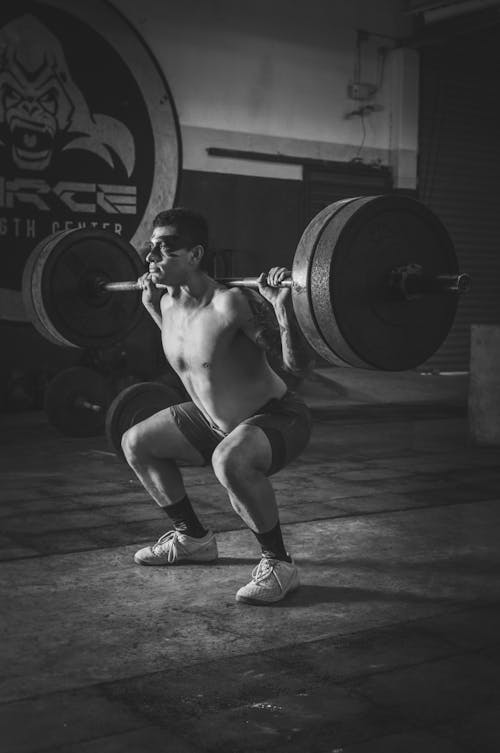 Monochrome Photo of Man Holding Barbell