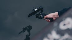 一个人手持智能手机万向节站在水面上，展现了现代技术的实际运用