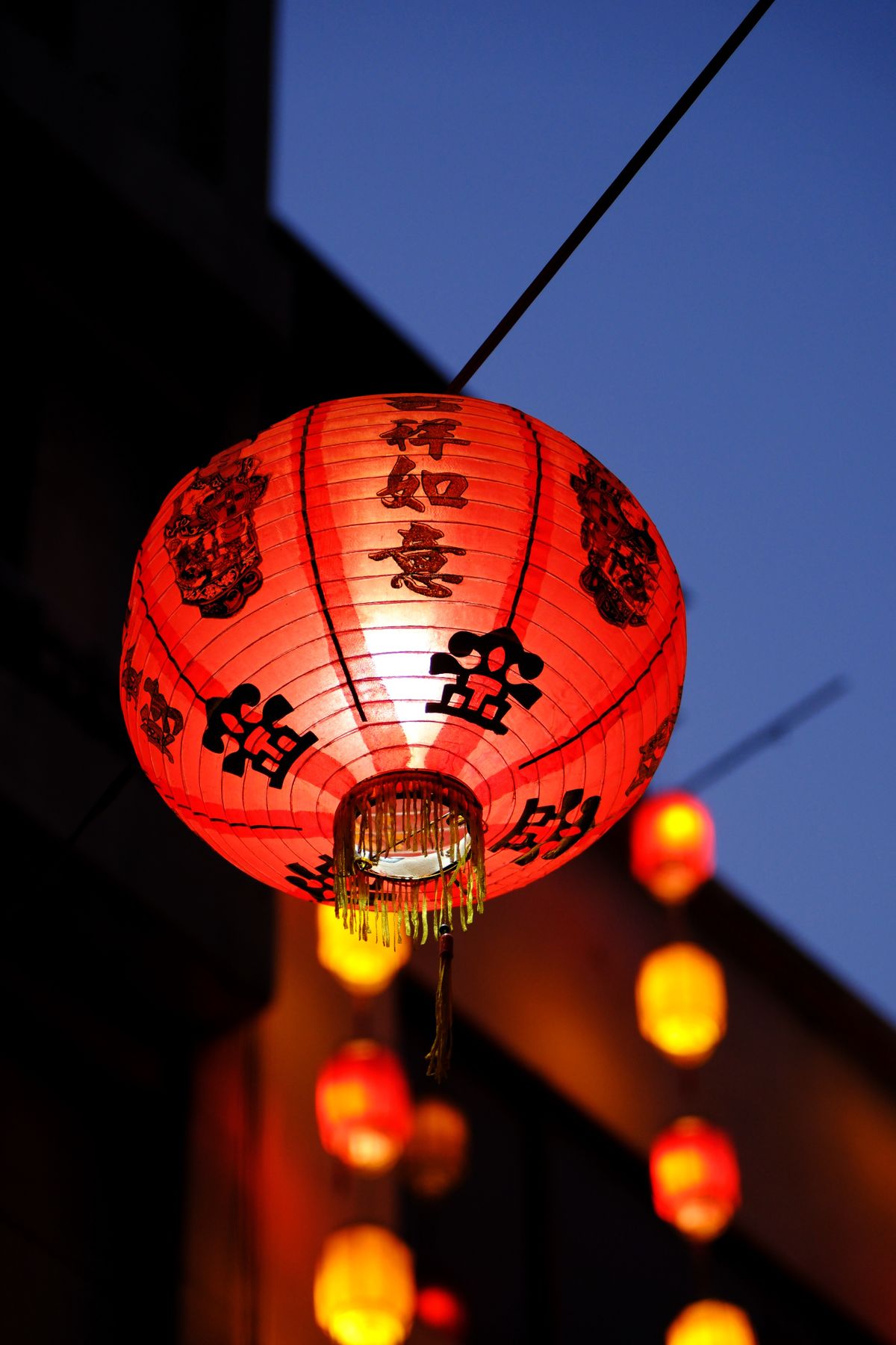 Red Chinese lanterns glowing at night — the visual language of a living Chinatown