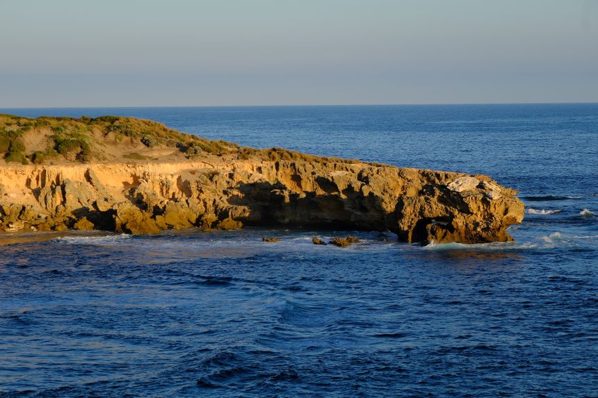 Coastal cliff reflected in the ocean at last light — Walter Coppola on Pexels
