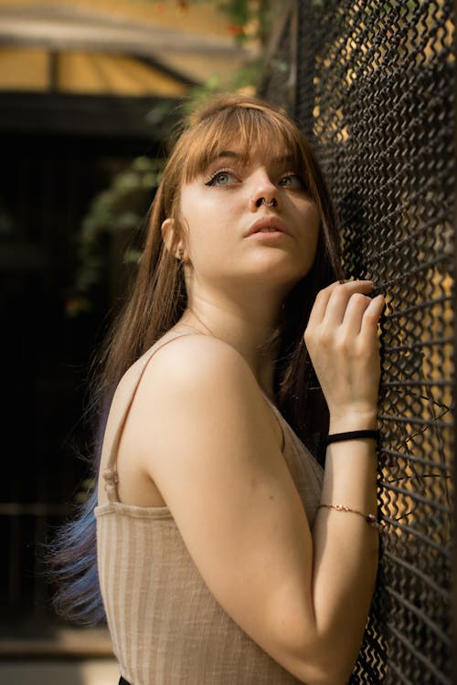 Photo of Woman Leaning on Wire Mesh