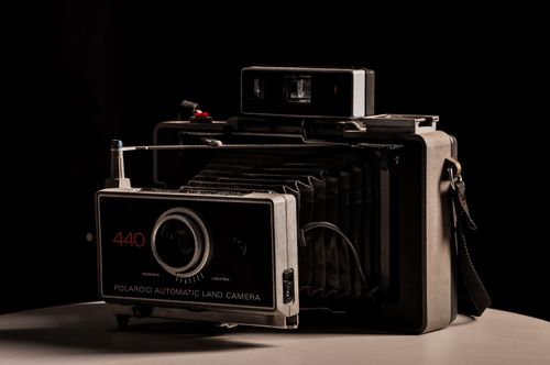 Free Close-up of a classic Polaroid Automatic Land Camera against a dark background. Retro photography art. Stock Photo