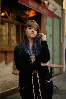 一位自信的年轻女子身着时尚服装，在城市街道上摆出姿势