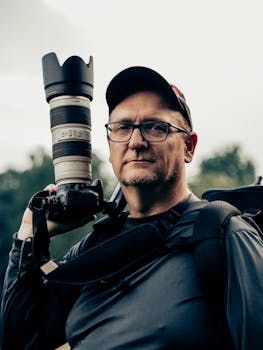 Portrait of a photographer carrying a camera with a telephoto lens outdoors in Atlanta.