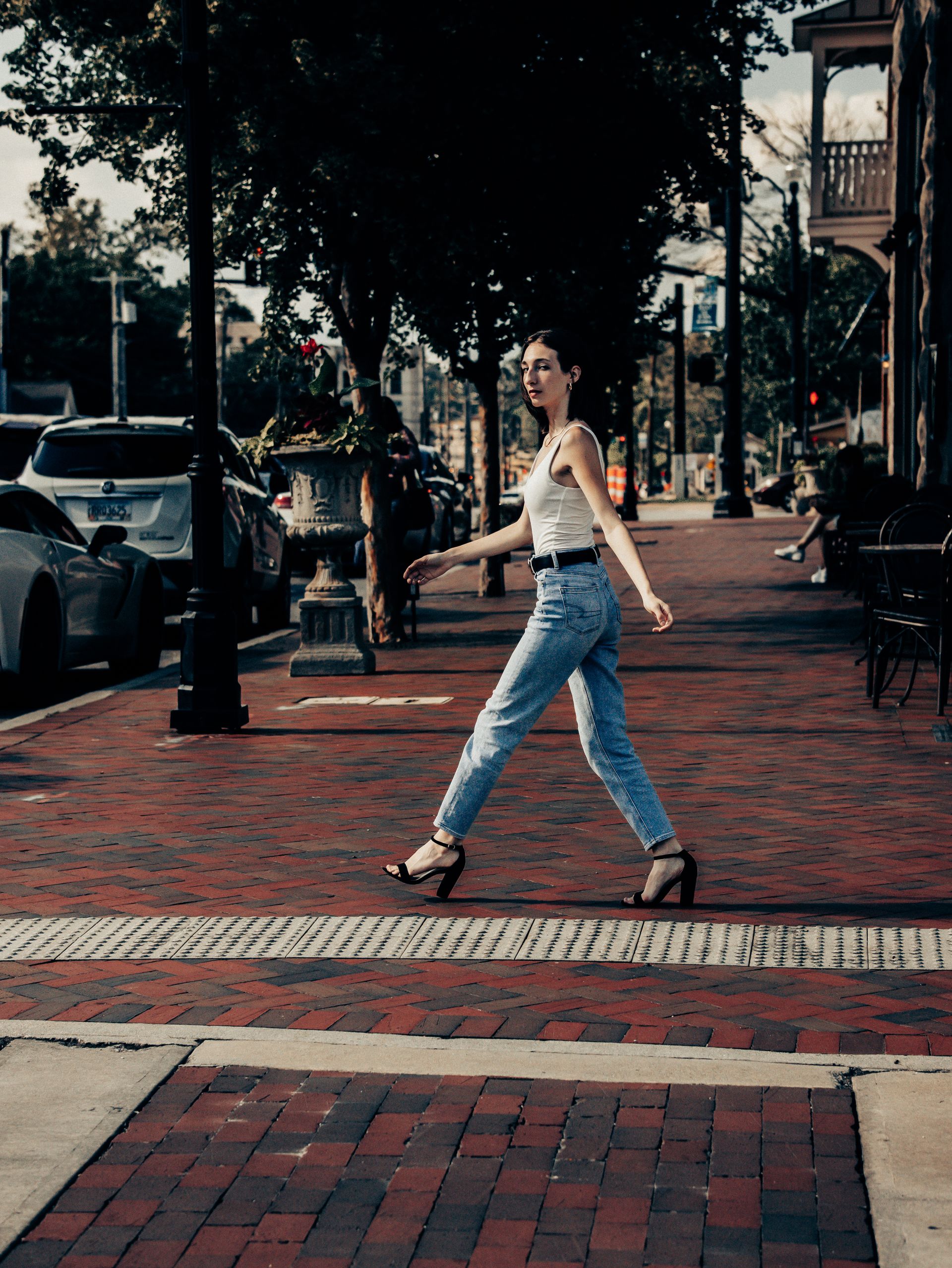 Editorial denim fashion — woman walking in jeans through the city