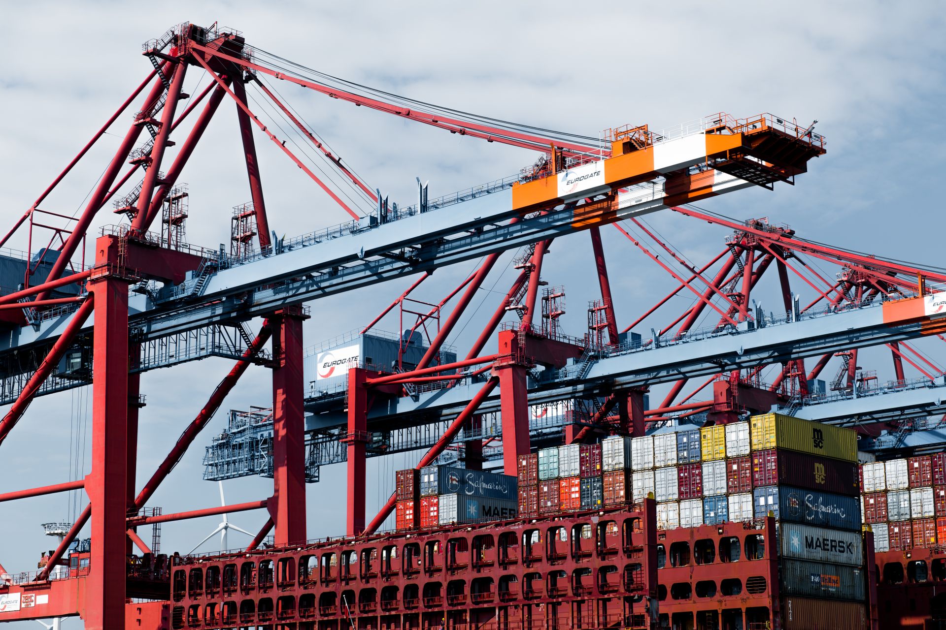 Stacked shipping containers and a port crane at a European harbour.