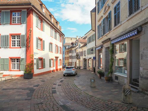 A cobblestone street with cars parked in front of it