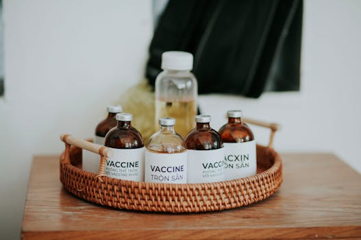 Vaccine bottles with labels placed on a wicker tray indoors, showcasing a healthcare setup.