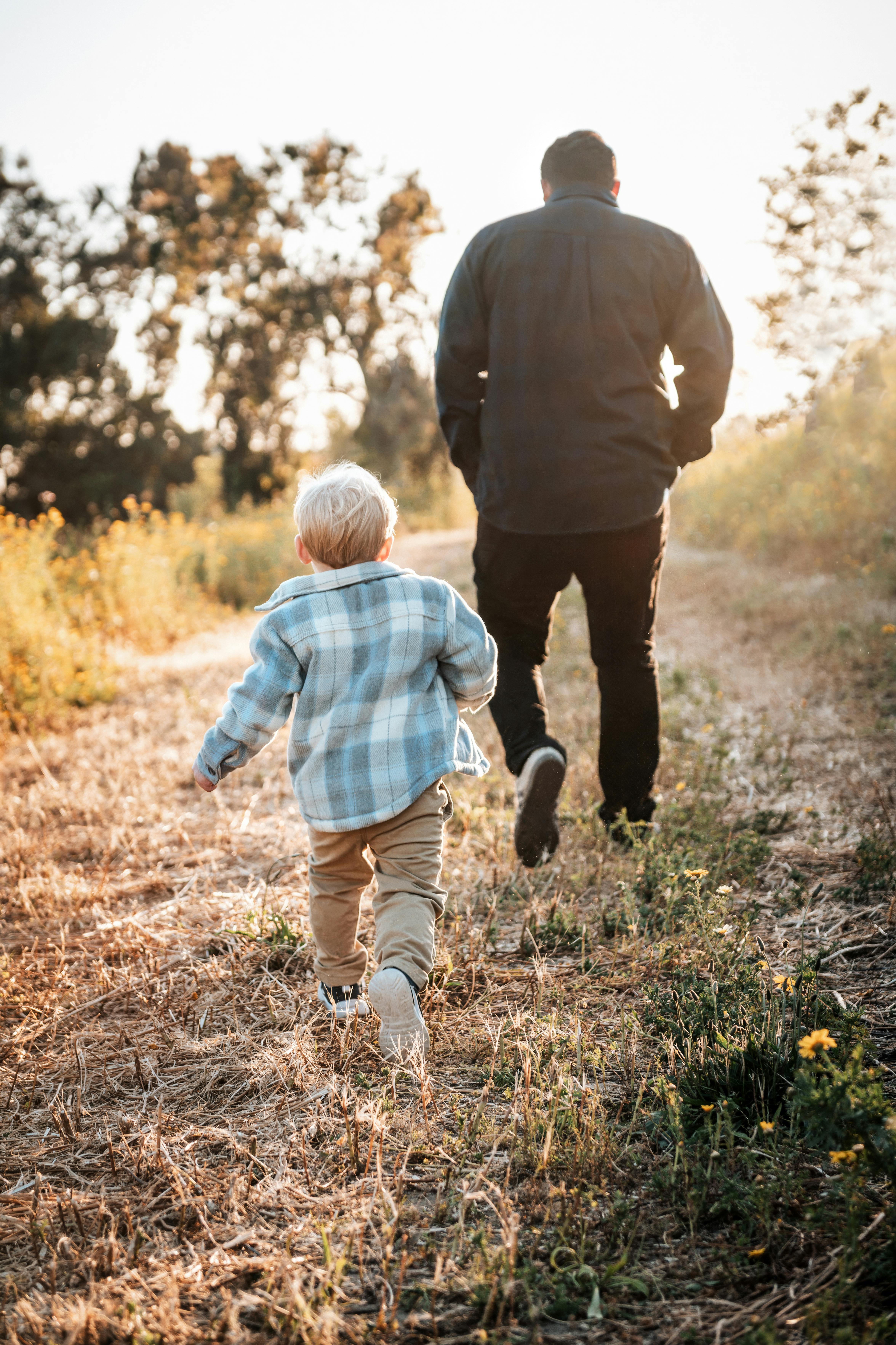 father and son on a field in sunlight