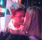 在剑桥，一对年轻夫妇在充满活力的霓虹灯下温柔地接吻