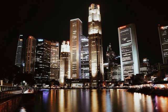 Illuminated skyline reflecting in water, showcasing Singapore's modern architecture. Related image for Market Trends: Key Lessons for Owners and Operators.