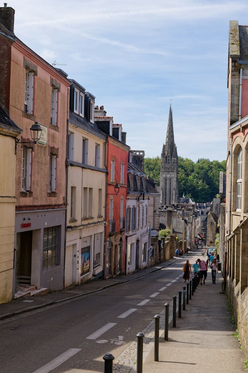 A narrow street with buildings and a church tower