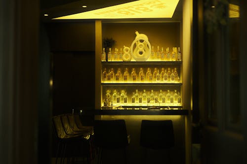 A bar with bottles and a lighted shelf