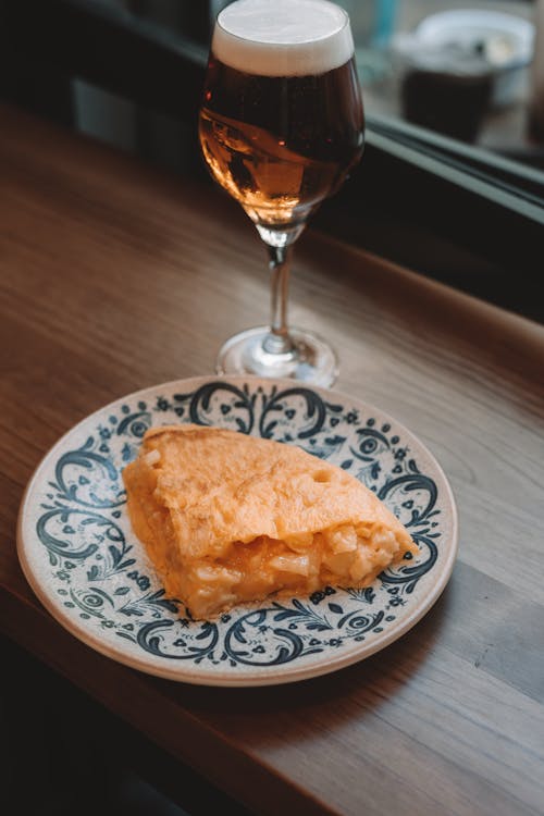 A plate with a piece of pie and a glass of beer