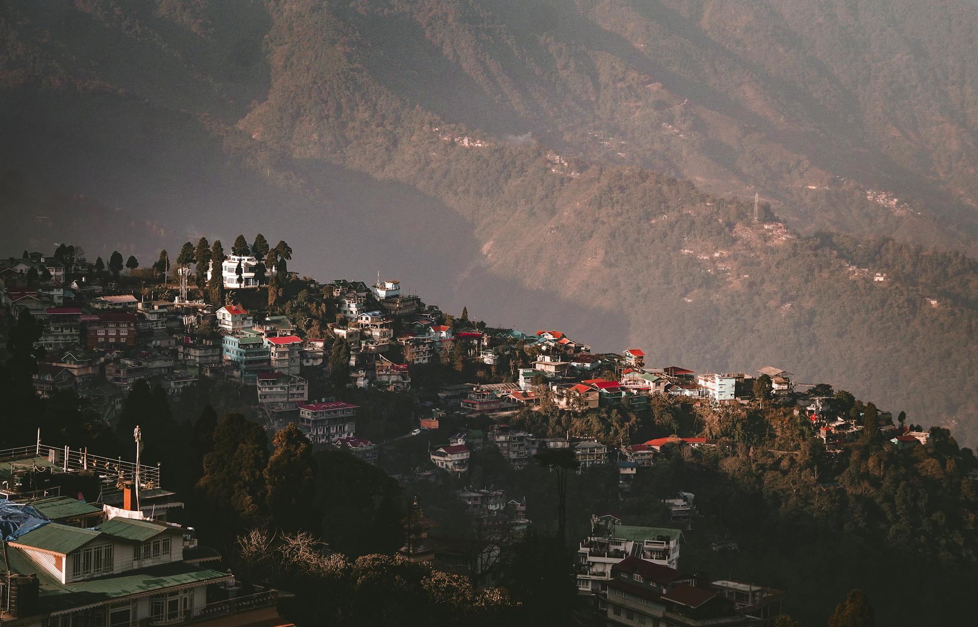 Aerial view of Darjeeling with vibrant houses nestled in the verdant hills of West Bengal, India.