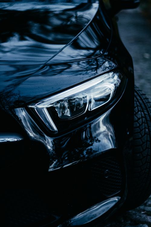 Free Close-up of a modern car's sleek headlight at night, showcasing automotive elegance in Berlin. Stock Photo