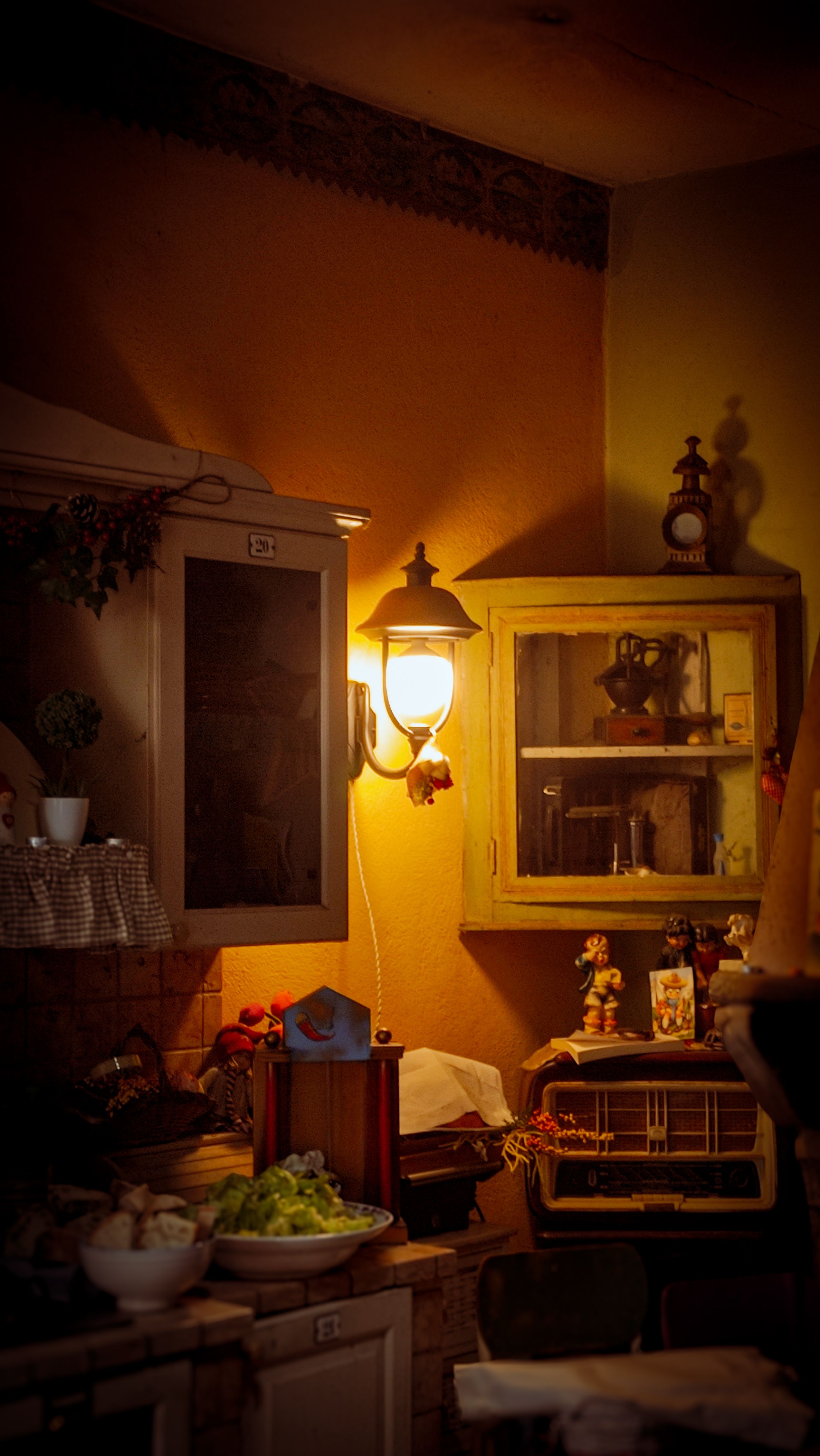 Atmospheric vintage kitchen interior with rustic cabinets and warm lamp light.