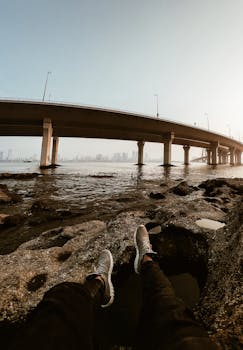 一个人坐在孟买海连桥边的岩石海岸上欣赏景色